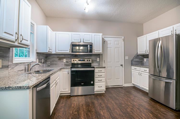 Free Bright modern kitchen featuring white cabinets and stainless steel appliances. Stock Photo