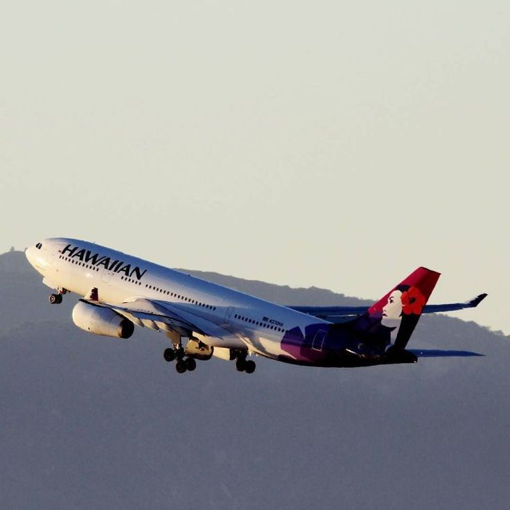 This may contain: a large jetliner flying through a sky with mountains in the background