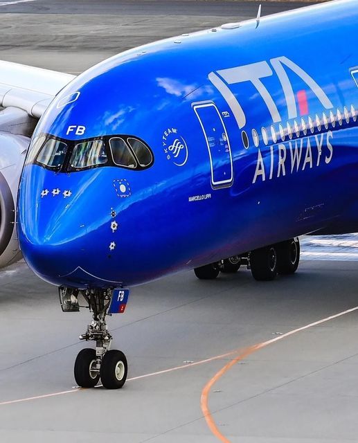 This may contain: a large blue jetliner sitting on top of an airport tarmac